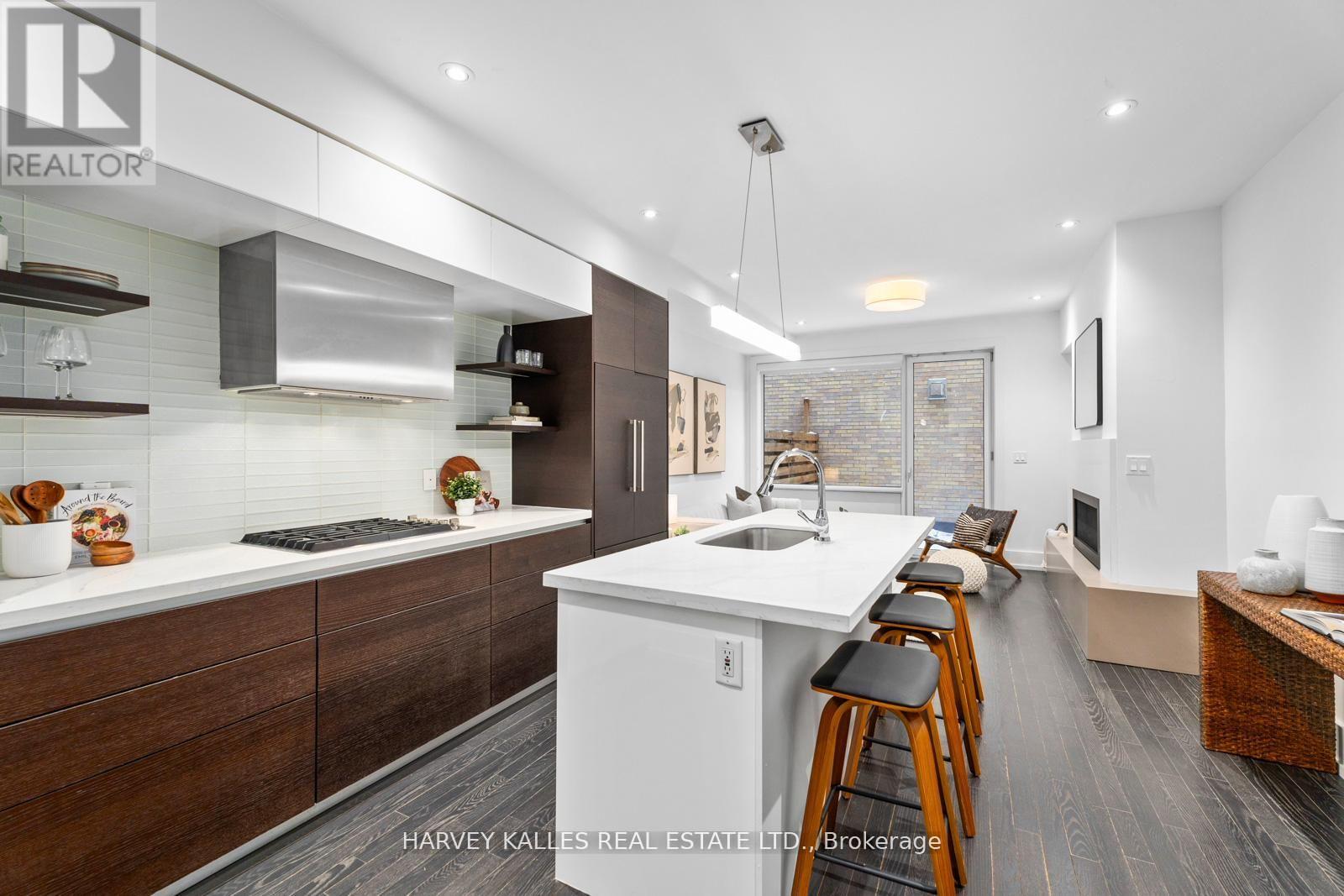 A modern kitchen with dark wood cabinets and white countertops.