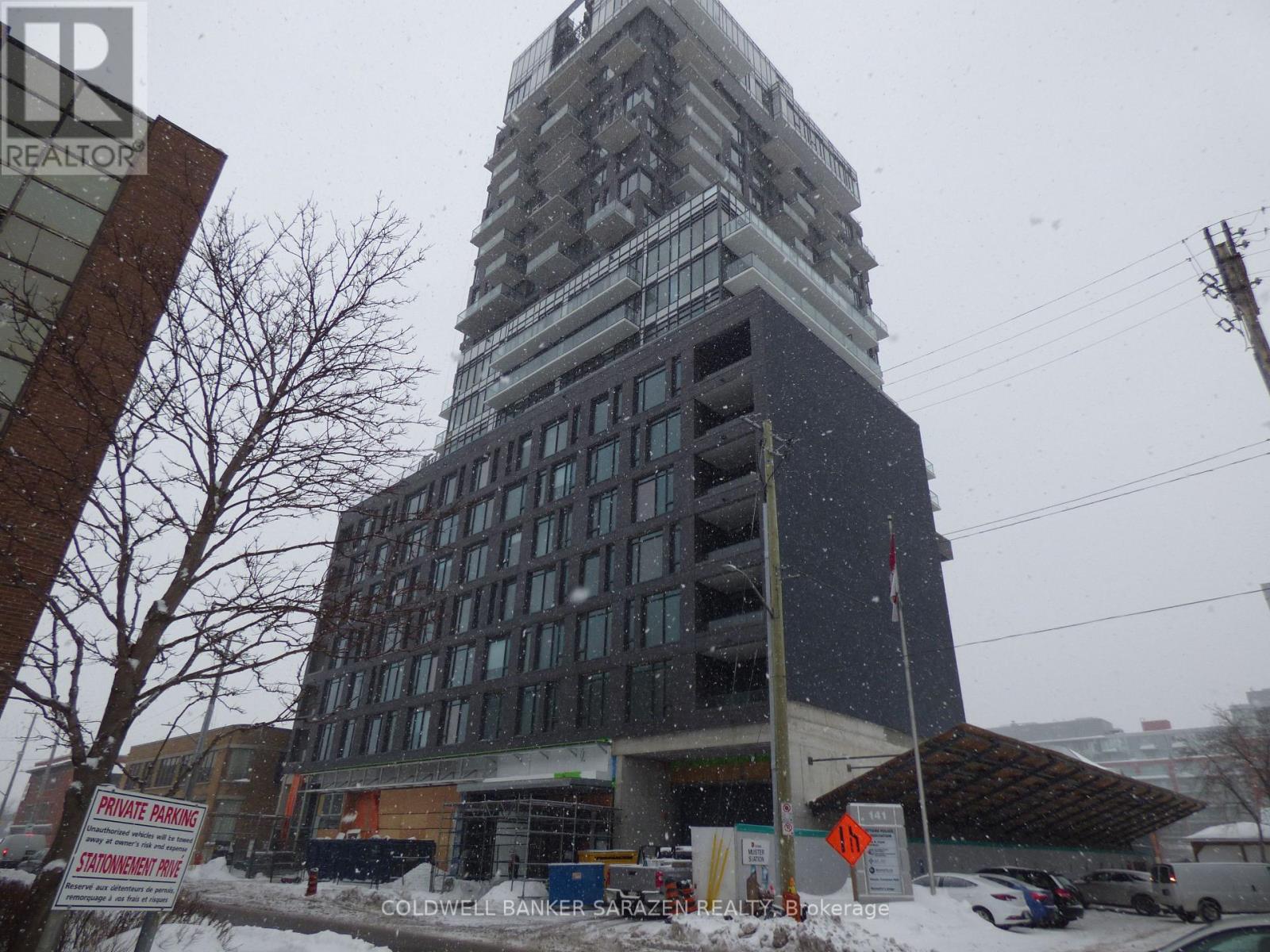 A tall building under construction with a sign that reads "Coldwell Banker Sager Real Estate.".