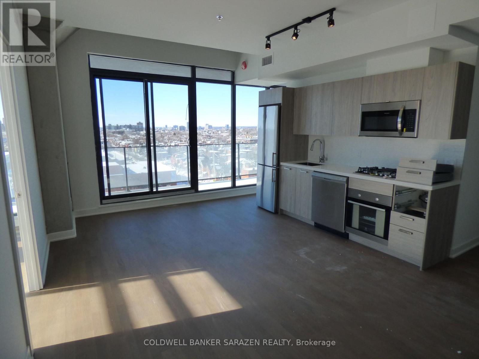 A spacious kitchen and living room with a view of the city.