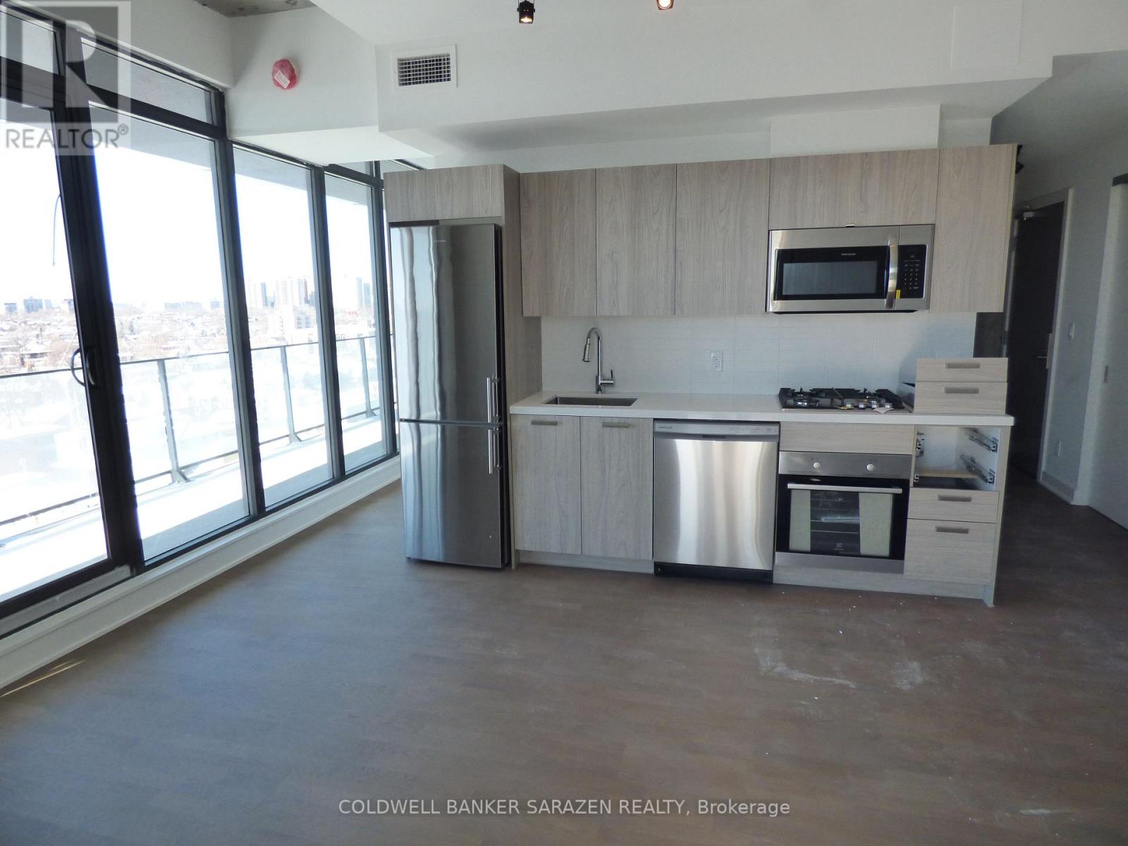 A kitchen with a stainless steel dishwasher and oven, a microwave, and a sink.
