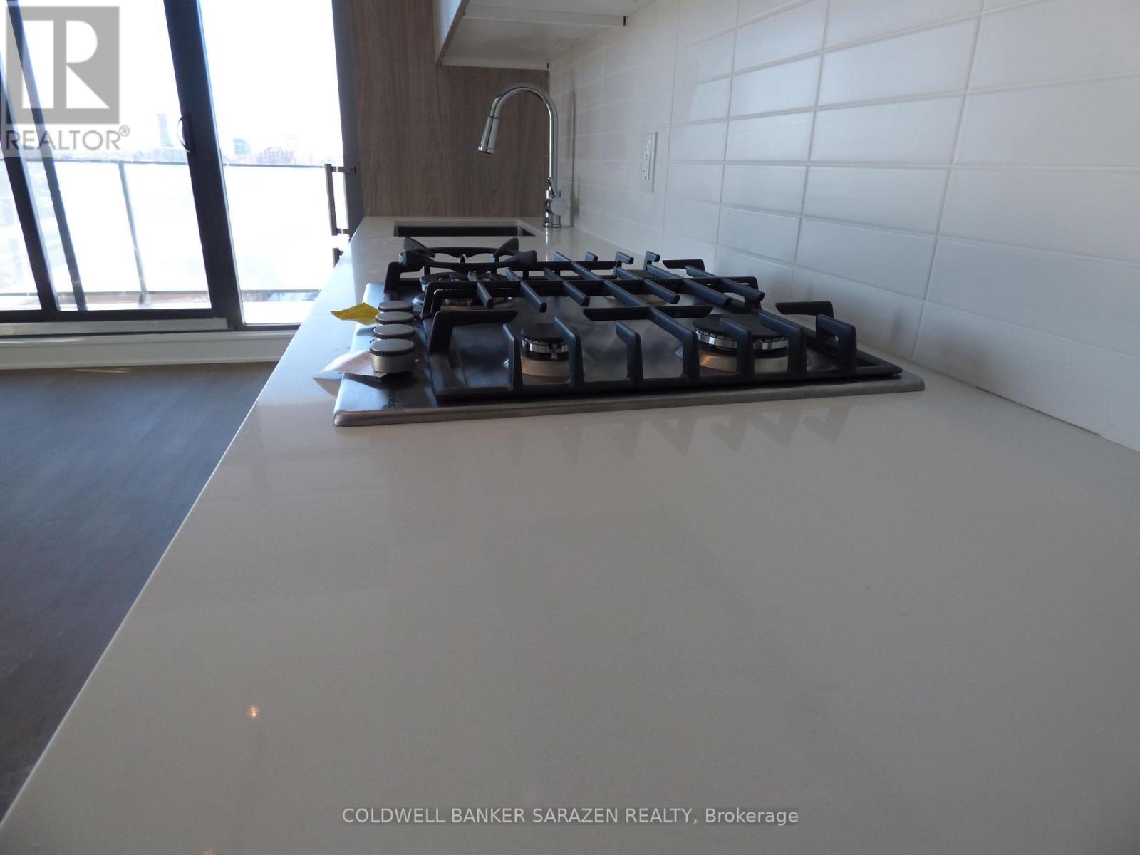 A modern kitchen with a large island and a gas stove.
