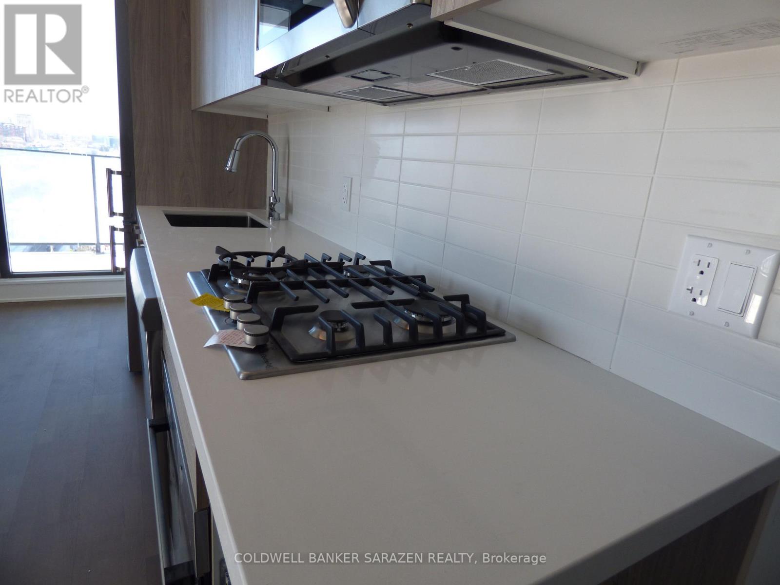 A modern kitchen with a white countertop and a black gas stove.