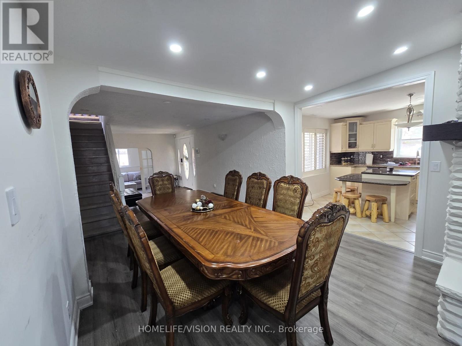 A dining room with a wooden table and chairs.
