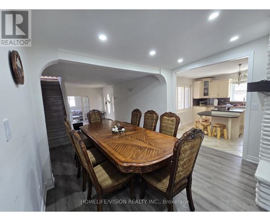 A dining room with a wooden table and chairs.