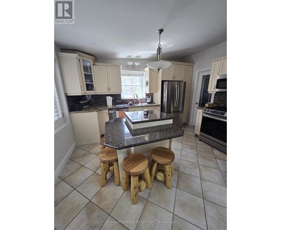 A kitchen with a granite countertop and wooden stools.