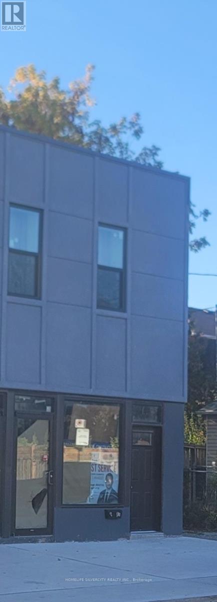 A modern building with a black facade and glass windows.