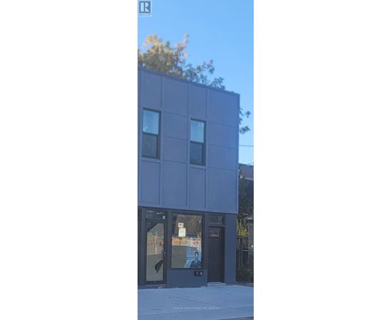 A modern building with a black facade and glass windows.