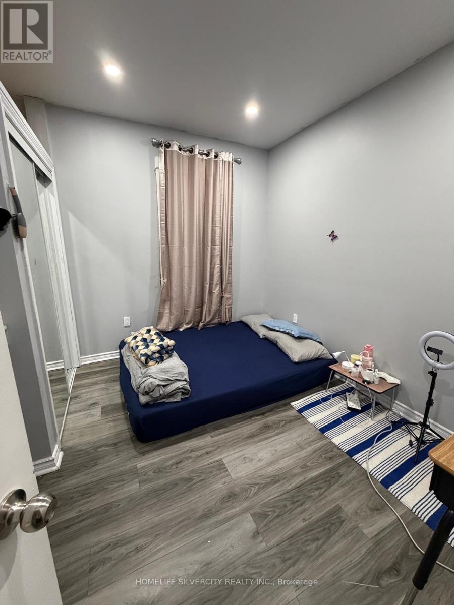 A bedroom with a bed, nightstand, and a striped rug.