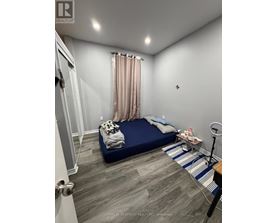 A bedroom with a bed, nightstand, and a striped rug.