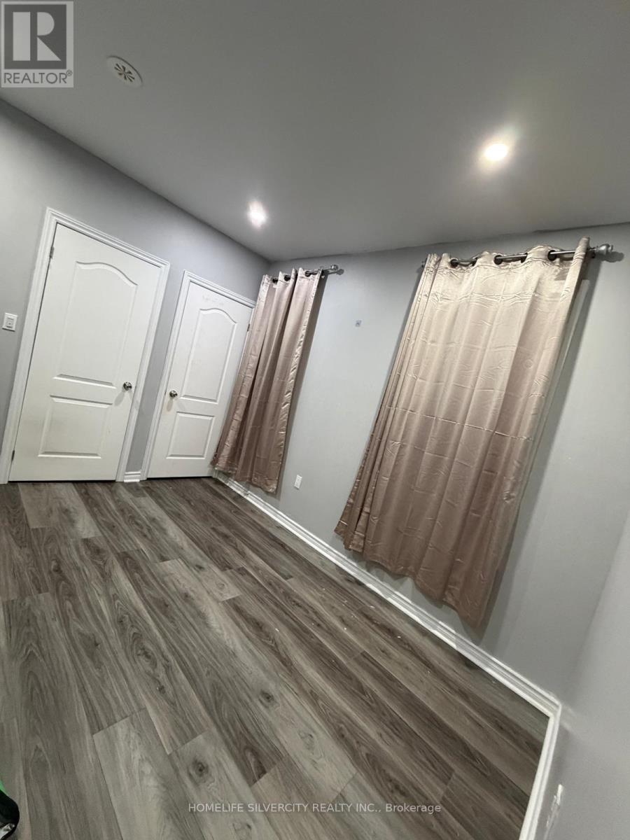 A room with wood flooring and white walls.