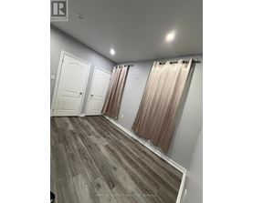 A room with wood flooring and white walls.