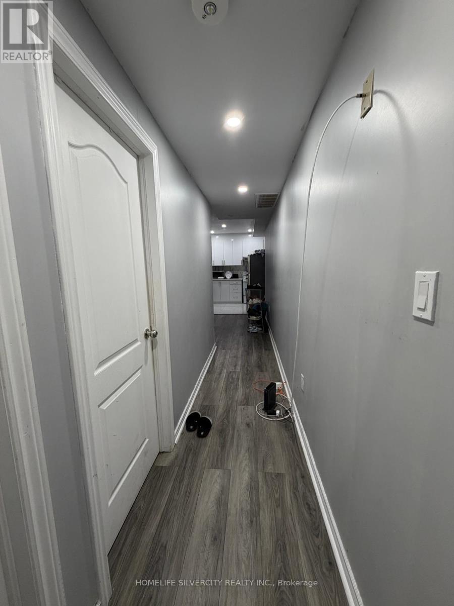 A long hallway with a door on the left and a hole in the floor on the right.
