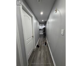 A long hallway with a door on the left and a hole in the floor on the right.