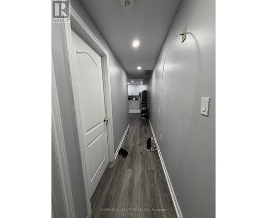 A long hallway with a door on the left and a hole in the floor on the right.