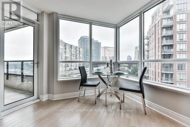 A dining room with a table and chairs in front of a window overlooking a cityscape.