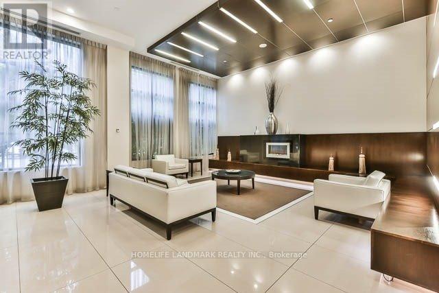 A spacious living room with white furniture and a large window.