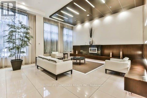 A spacious living room with white furniture and a large window.