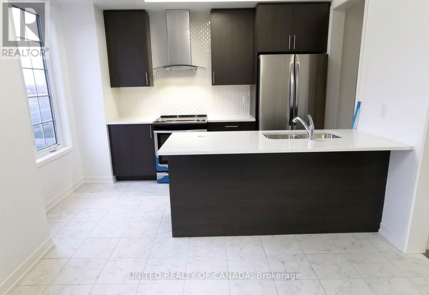 A kitchen with black cabinets and a white countertop.