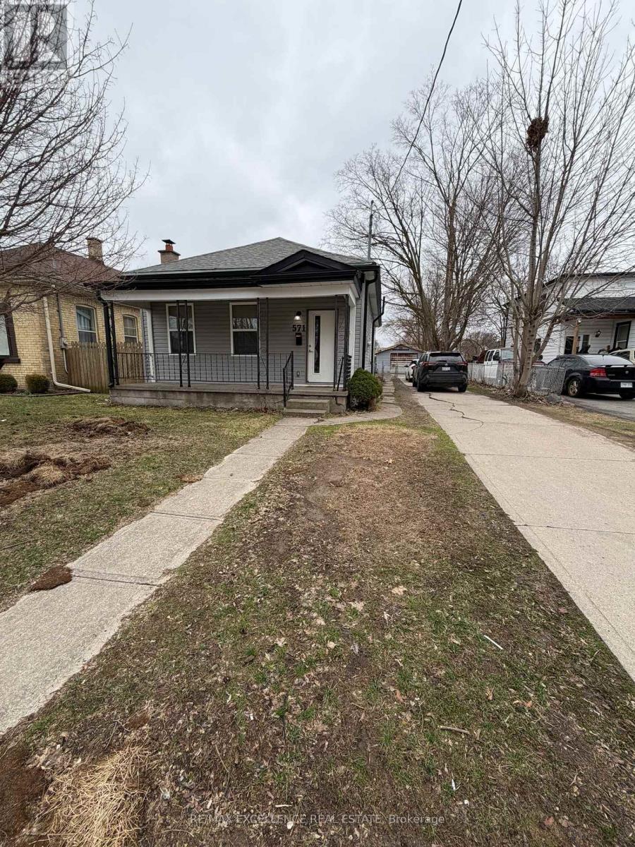 A small house with a front yard and a car parked in front.