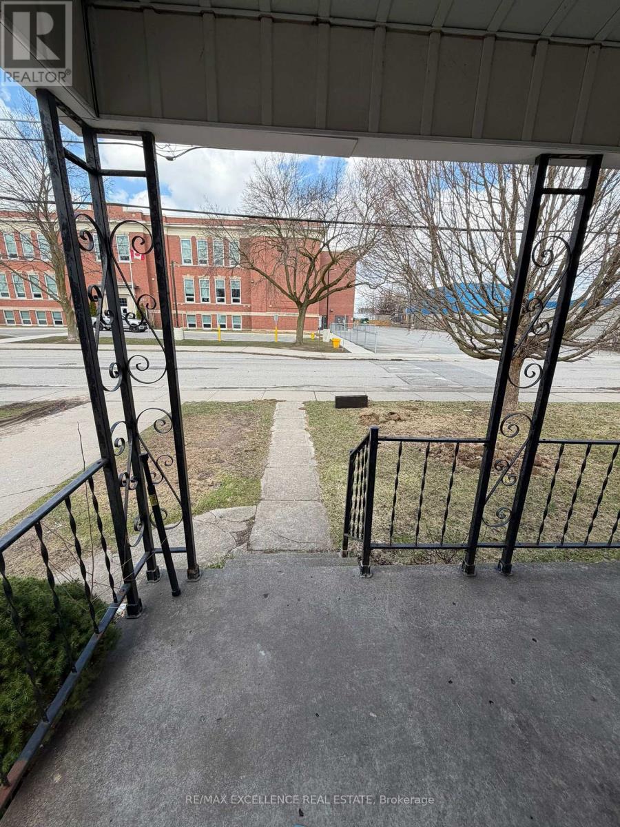 A view from a porch looking out at a brick building.