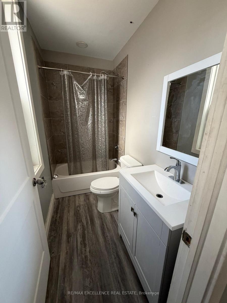 A bathroom with a toilet, sink, and shower.