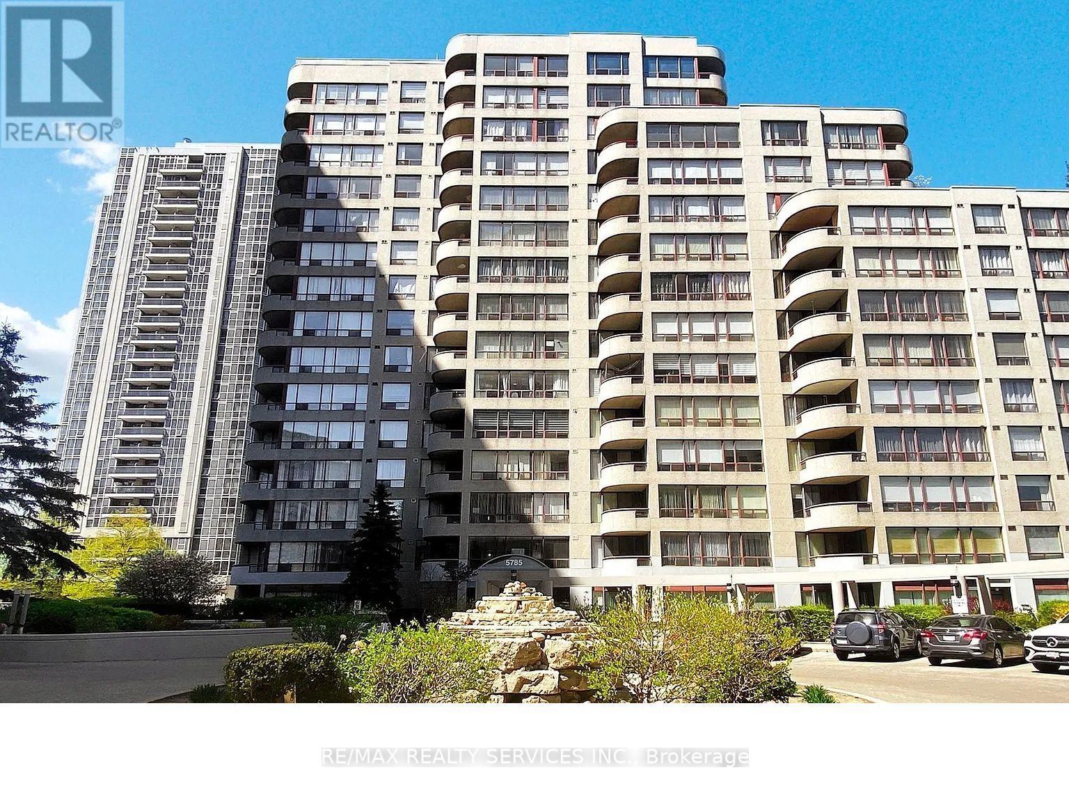 A large residential building with a parking lot in front.