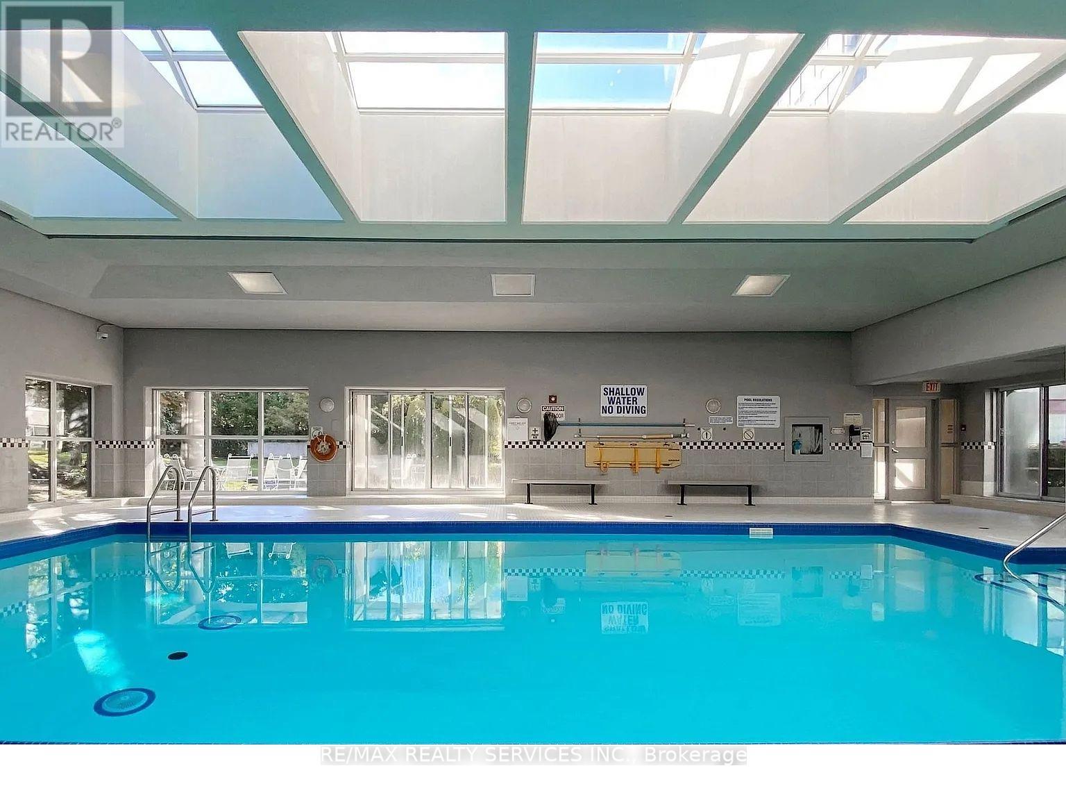 A large indoor swimming pool with a glass ceiling.