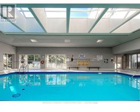 A large indoor swimming pool with a glass ceiling.