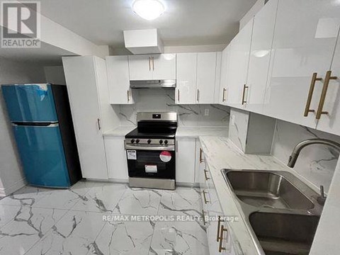 A kitchen with white cabinets and a marble countertop.