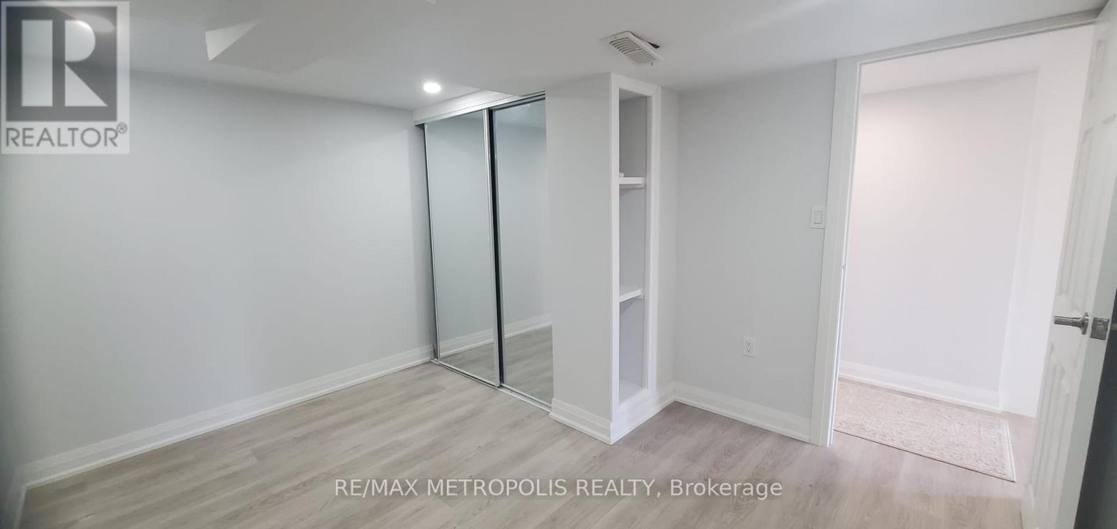 A white room with a sliding door and a wooden floor.