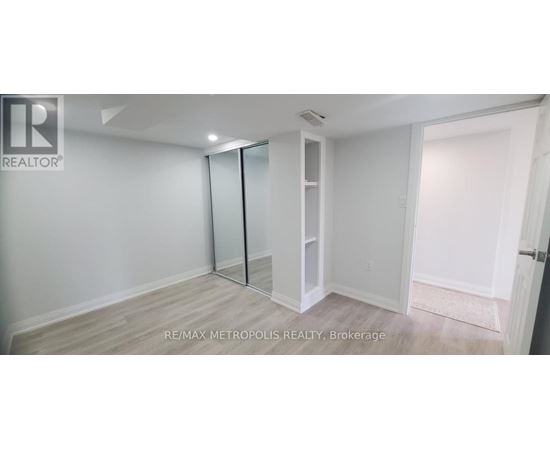 A white room with a sliding door and a wooden floor.