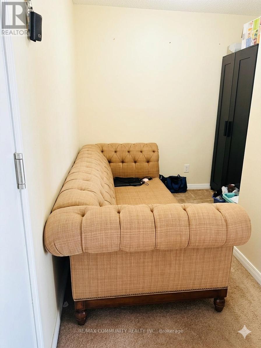 A bed with a tufted headboard is in a small bedroom.