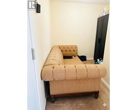 A bed with a tufted headboard is in a small bedroom.