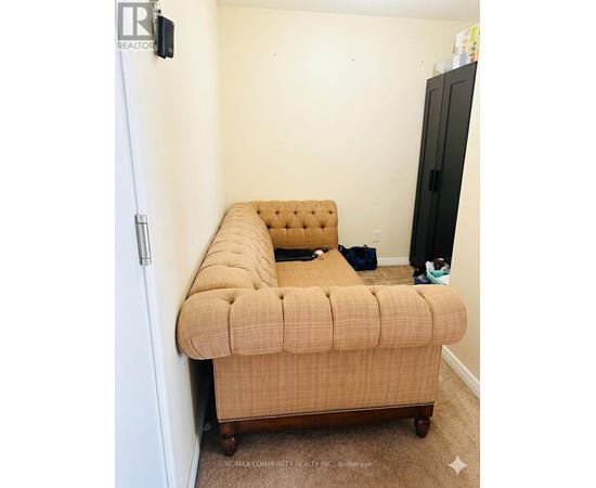 A bed with a tufted headboard is in a small bedroom.