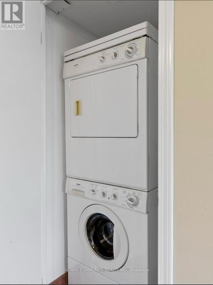 A white dryer and washer stacked on top of each other in a small space.