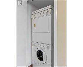 A white dryer and washer stacked on top of each other in a small space.