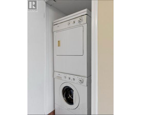 A white dryer and washer stacked on top of each other in a small space.