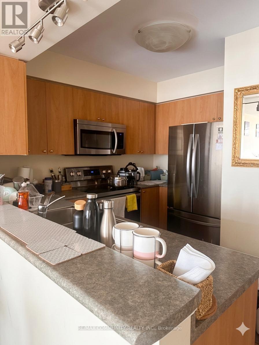 A kitchen with a refrigerator, microwave, and oven.