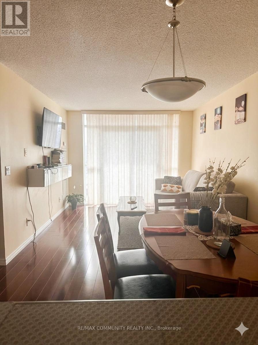 A dining room with a table set for two and a television mounted on the wall.