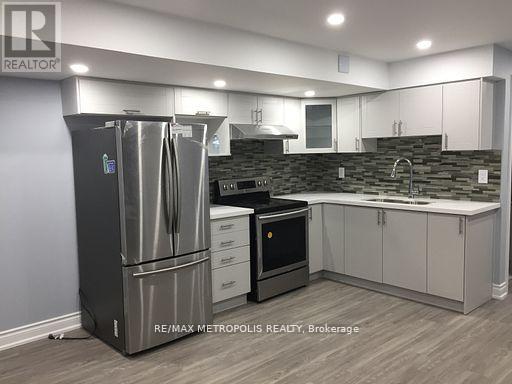 A modern kitchen with a stainless steel refrigerator and white cabinets.