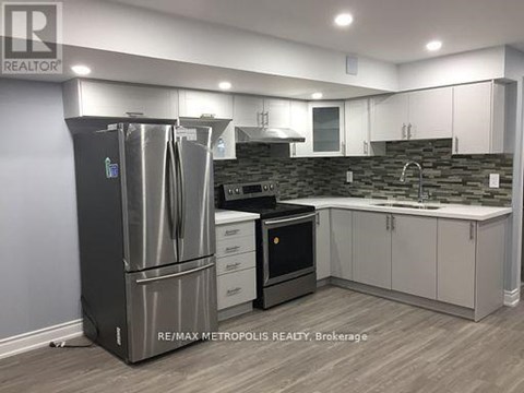 A modern kitchen with a stainless steel refrigerator and white cabinets.
