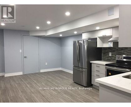 A kitchen with a refrigerator, stove, and cabinets.