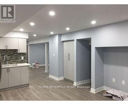 A room with a sink and cabinets in a building under construction.