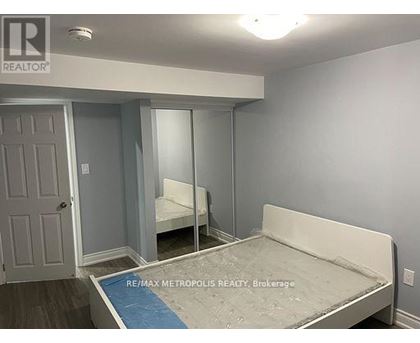 A bedroom with a bed, mirror, and closet.