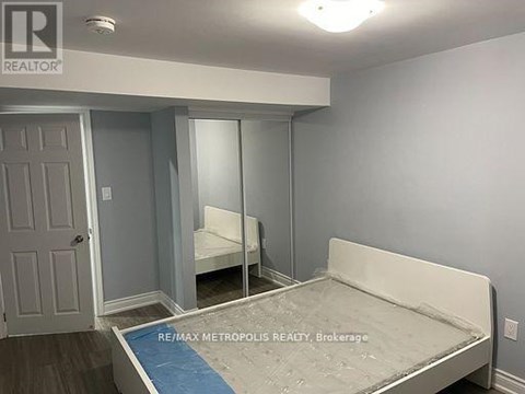 A bedroom with a bed, mirror, and closet.