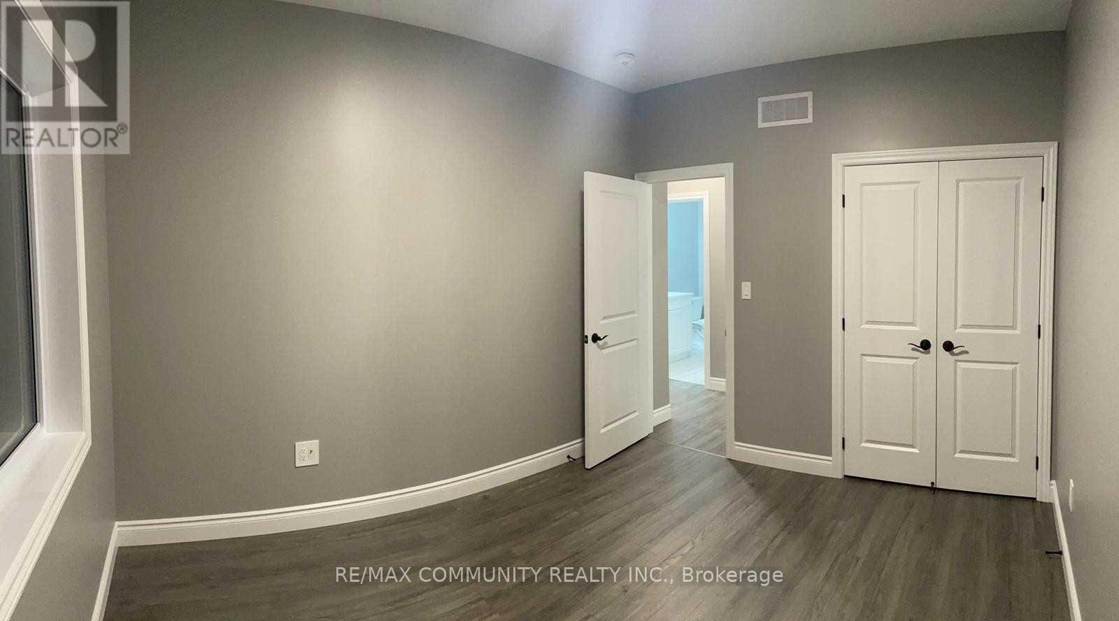 A room with a grey wall and a white door.