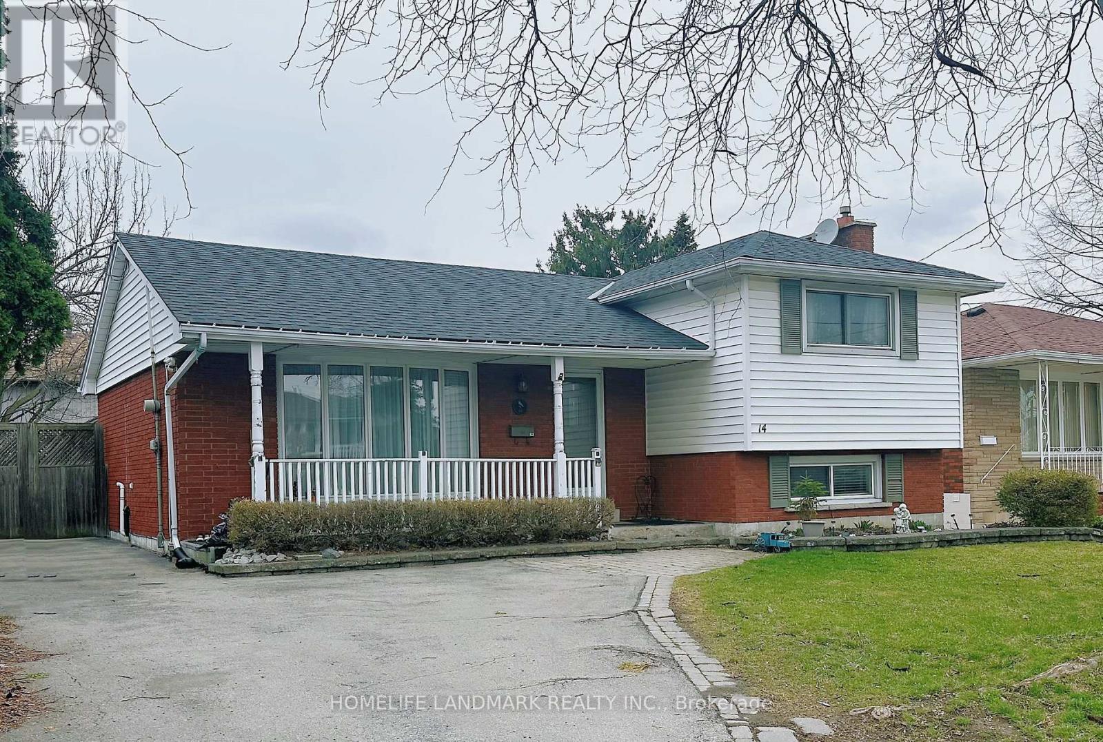 A two-story house with a red brick exterior and a white front porch.