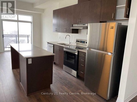 A kitchen with a stainless steel refrigerator and a wooden island.
