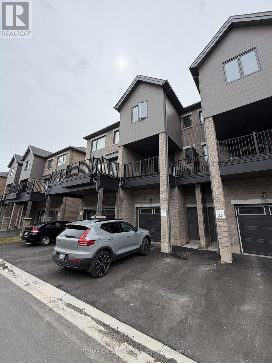 A realtor photo of a grey two-story apartment building with a car parked in front.