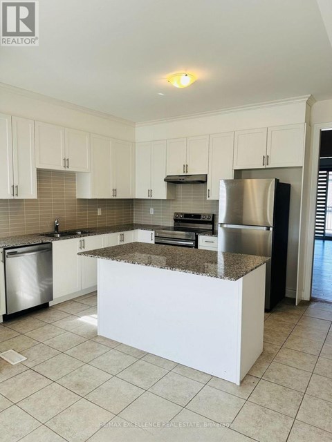 A kitchen with white cabinets and a granite countertop.